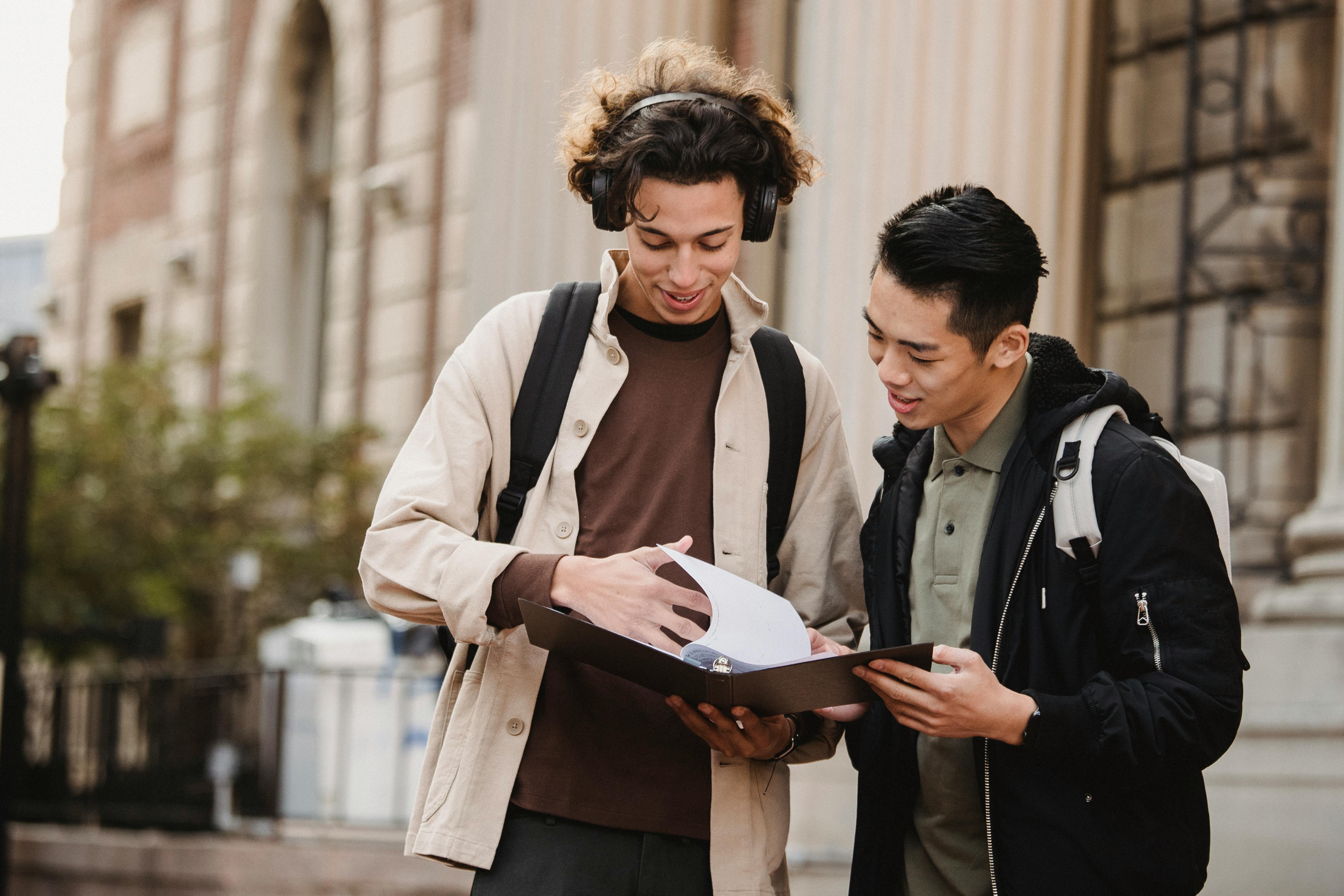 Two students sharing notes in a college campus
